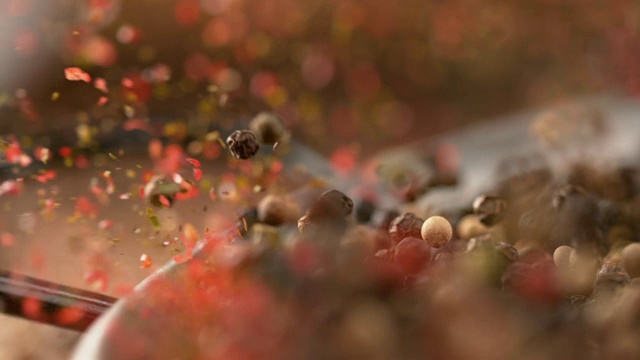 微距，深度:芬芳的花椒从金属煎锅里蹦出来。视频素材