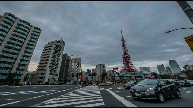 4K时间推移-拥挤的人们通过与汽车的速度在后面的东京塔在晚上-日本东京视频素材