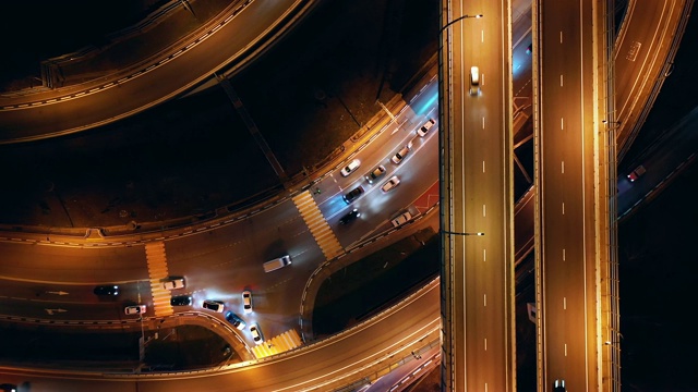 用四轴飞行器进行航空摄影。夜晚的道路。相机顺时针向下移动。晚上公路上的照明城市交通。视频素材