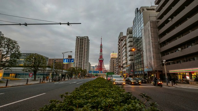 4K时间推移-缩放在东京塔东京日本的标志性建筑与汽车和交通灯在晚上与草地前景-日本东京视频素材