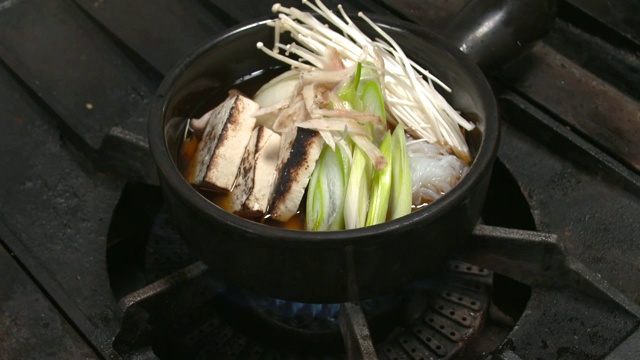 煤气炉在炉台上点火做Sukiyaki(日式料理，以日式火锅的方式准备和食用)视频素材