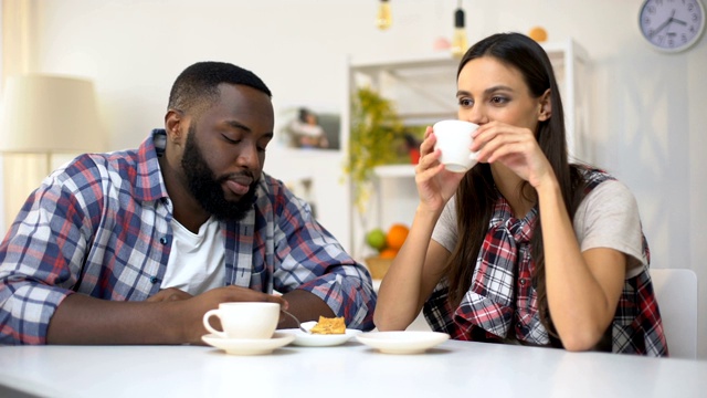 年轻的混血夫妇在吃甜点，女人在擦男朋友嘴唇上的护肤霜视频素材