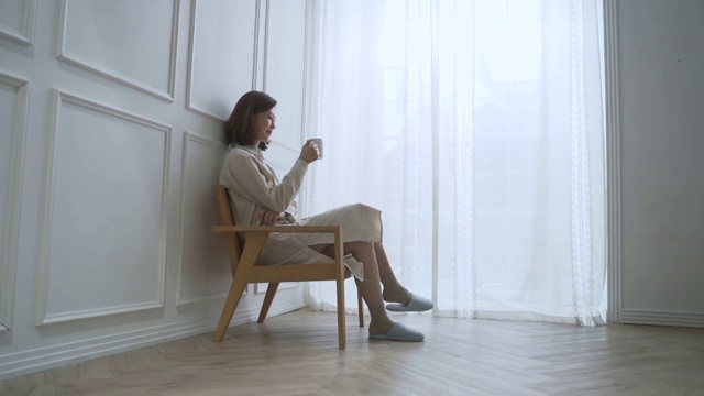 一位中年妇女坐下来喝着咖啡视频素材画面1