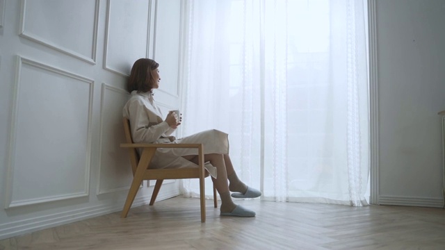 一位中年妇女坐下来喝着咖啡视频素材画面2