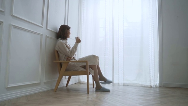 一位中年妇女坐下来喝着咖啡视频素材画面3
