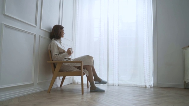 一位中年妇女坐下来喝着咖啡视频素材画面4