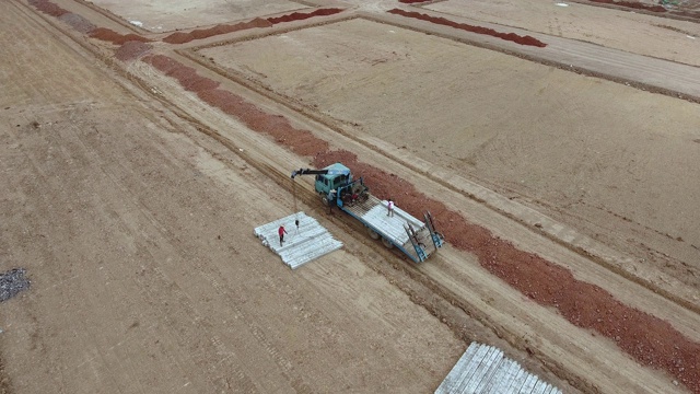 用于房屋建造的带有起重机卸柱的平板卡车的空中静态视图视频素材