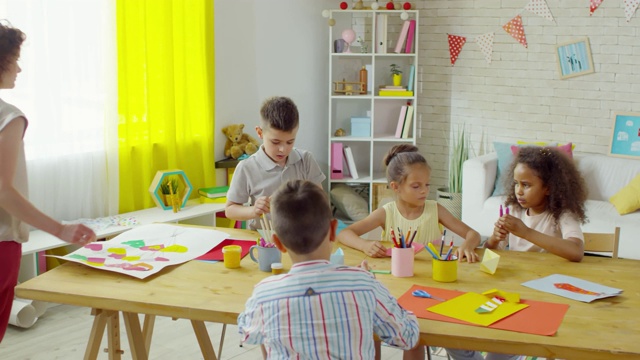 幼儿在幼儿园老师的帮助下制作折纸船视频素材