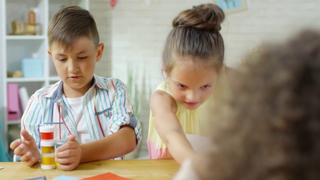 在幼儿园美术课上，孩子们准备用水粉画画视频素材