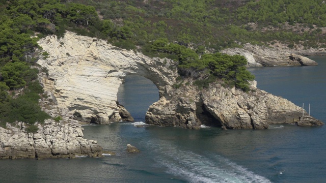 游览阿科迪圣费利斯，自然拱门在岩石海岸与白色石灰岩岩石视频素材