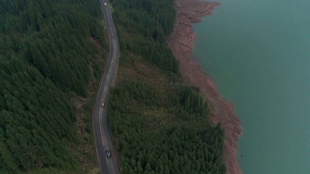 鸟瞰图四辆汽车在森林的乡村道路上行驶。4 k视频素材