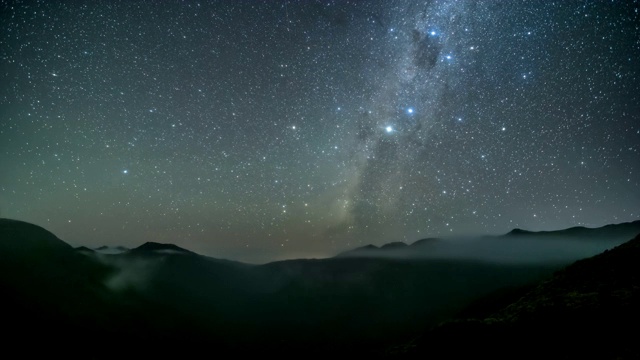 繁星点点的夜空，在云雾缭绕的群山中有银河的星星时光流逝，天文学视频素材