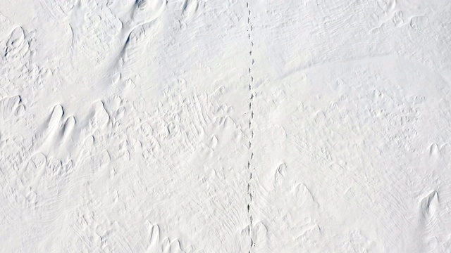 一个男人正走在雪地上。孤独。从以上观点。视频素材画面1