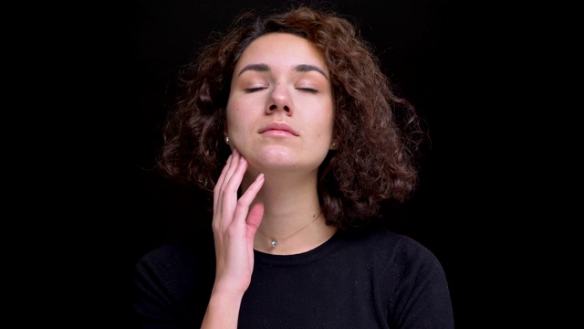 特写的年轻的现代白人女性与卷发得到头痛被惹恼，使一个眼睛滚动视频素材