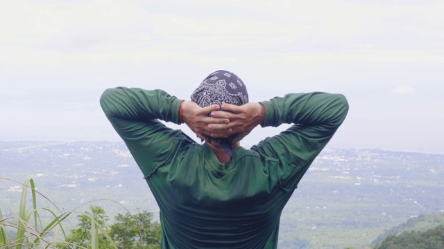 快乐的人放松，从山顶看山谷景观。旅人一边登山，一边从山顶欣赏美丽的风景。视频素材画面2