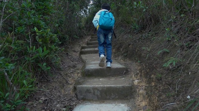 亚洲男孩沿着山路徒步旅行视频素材