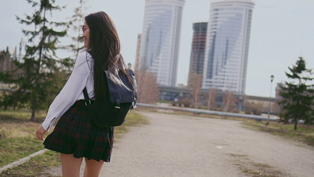 微笑的日本女学生在短裙跳沿着街道课后。视频素材