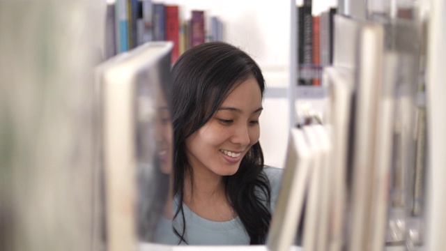 亚洲女学生在大学图书馆查找书籍。教育的概念视频素材