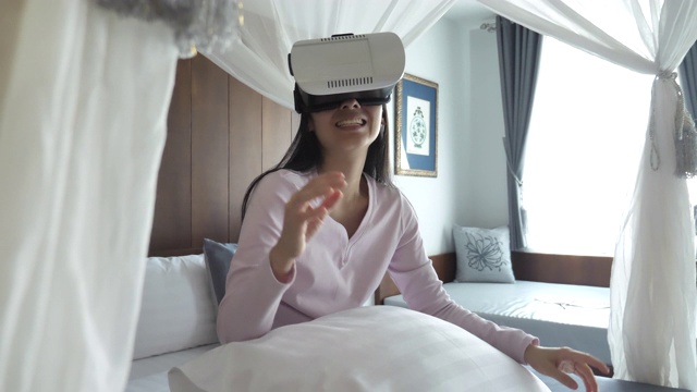 亚洲女人在虚拟现实头盔在家视频素材画面2
