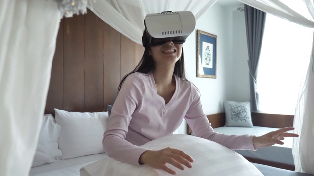 亚洲女人在虚拟现实头盔在家视频素材画面3