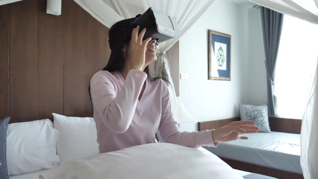 亚洲女人在虚拟现实头盔在家视频素材画面4