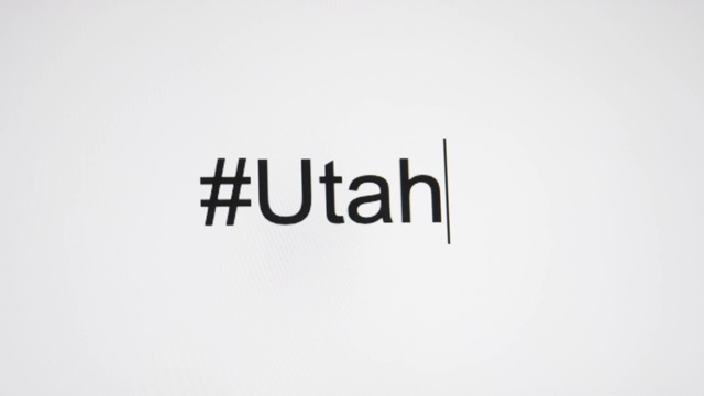 一个人在电脑屏幕上输入“#Utah”，然后是州的缩写视频素材画面1