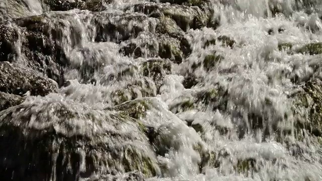 白色的水冲过石灰华岩石。视频素材