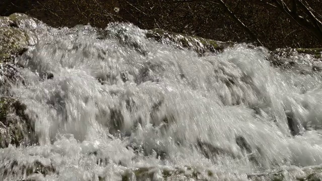 白色的水冲击着石灰华岩石。视频素材