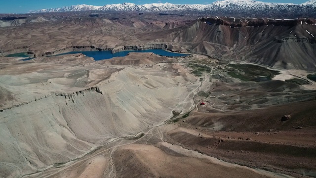 横扫空中转弯的山谷与蓝色的湖和雪山在背景。视频素材