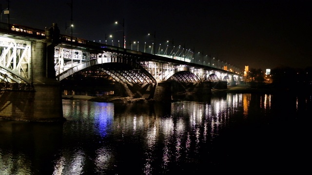 波兰华沙维斯瓦河上的波尼亚托斯基桥的全景夜景视频素材