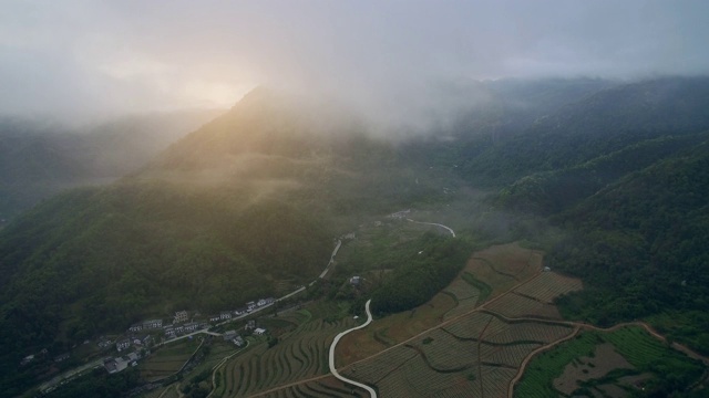 中国安康日出时小村庄和山路鸟瞰图。视频素材