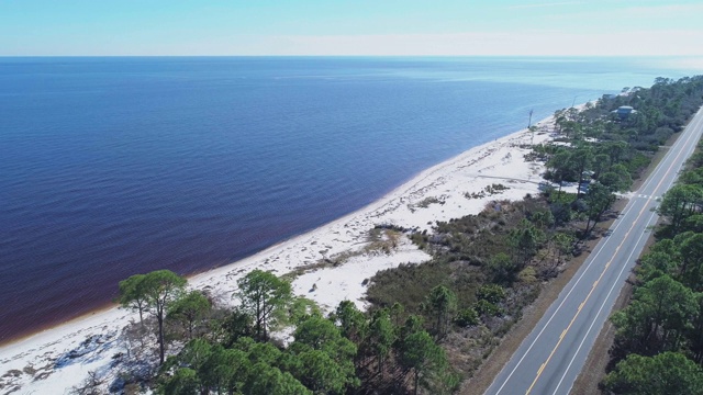沿着大西洋海岸的白色沙丘和松树林的高速公路。无人机视频与电影加速宽轨道，全景相机运动，飞越海洋。视频素材画面4