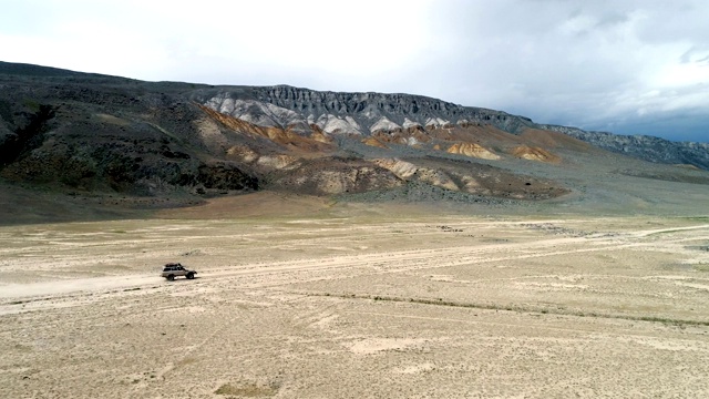 阿勒泰山游猎车辆在沙道上行驶的4K鸟瞰图视频素材