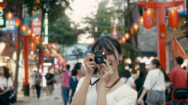 台湾千禧一代女性在西门町购物区用复古相机拍照(慢镜头)视频素材