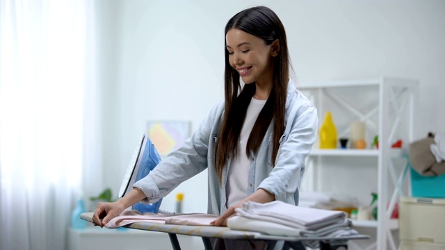 美丽的主妇心情好在家熨衣服，做家务视频素材画面2