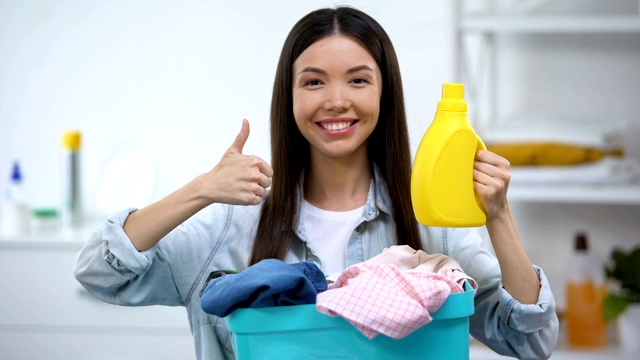 有一篮子衣服和洗衣粉的家庭主妇翘着大拇指视频素材