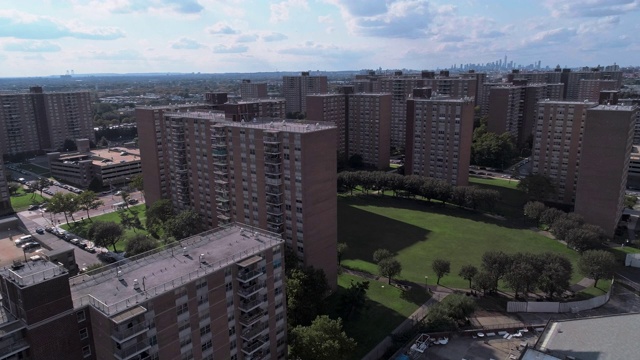 住宅区与多层次的社会“项目”砖建筑在布鲁克林，纽约，沿着宾夕法尼亚大道，与曼哈顿的远景。无人机视频与向前摄像机运动。视频素材