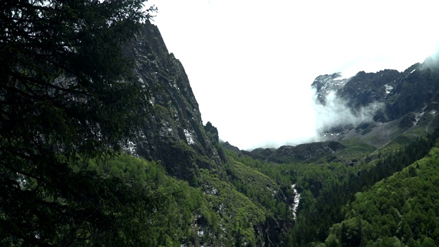 手持式低角度平移视图:四姑娘山之一从徒步覆盖阴雨多云的昌平沟山谷或昌平山谷，中国视频素材