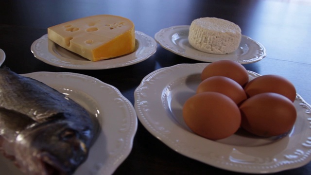 高蛋白的食物。生肉和鱼，奶酪，鸡蛋放在不同的盘子里。视频素材画面3