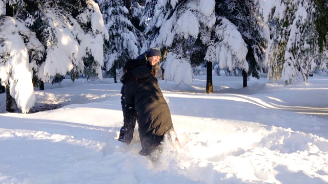 快乐的夫妇在冬天的森林里打雪仗和玩雪视频素材