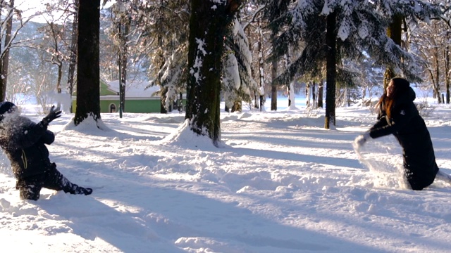 快乐的夫妇在冬天的森林里打雪仗和玩雪视频素材