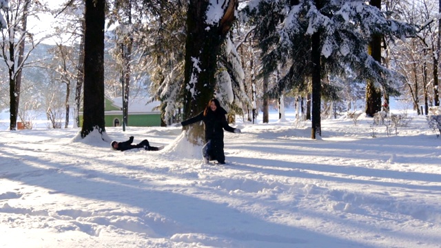 快乐的夫妇在冬天的森林里打雪仗和玩雪视频素材