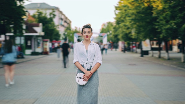 放大时间流逝，严肃的女人在休闲服装站在繁忙的街道视频素材画面1