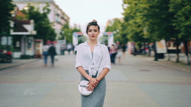 放大时间流逝，严肃的女人在休闲服装站在繁忙的街道视频素材画面3