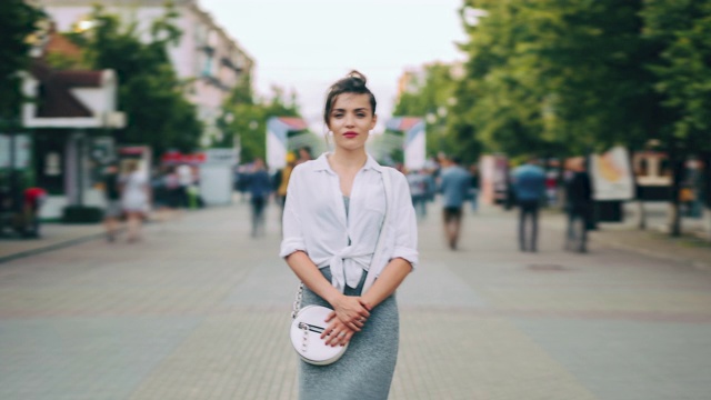 放大时间流逝，严肃的女人在休闲服装站在繁忙的街道视频素材画面4