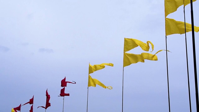 在夏季节日期间，在天空背景的旗杆上飘扬五颜六色的横幅视频素材画面2