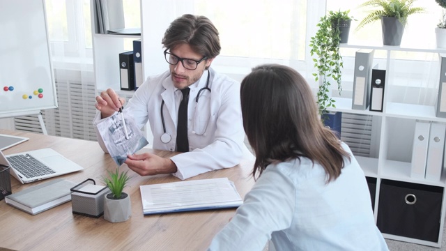 医生向一位女士解释牙科x光照片视频素材