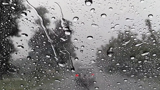 雨点落在挡风玻璃上。视频素材