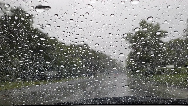 开车时，雨点落在挡风玻璃上。视频素材