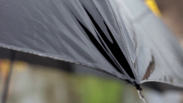 电影摄影车拍摄的雨滴从黑色的伞。视频素材